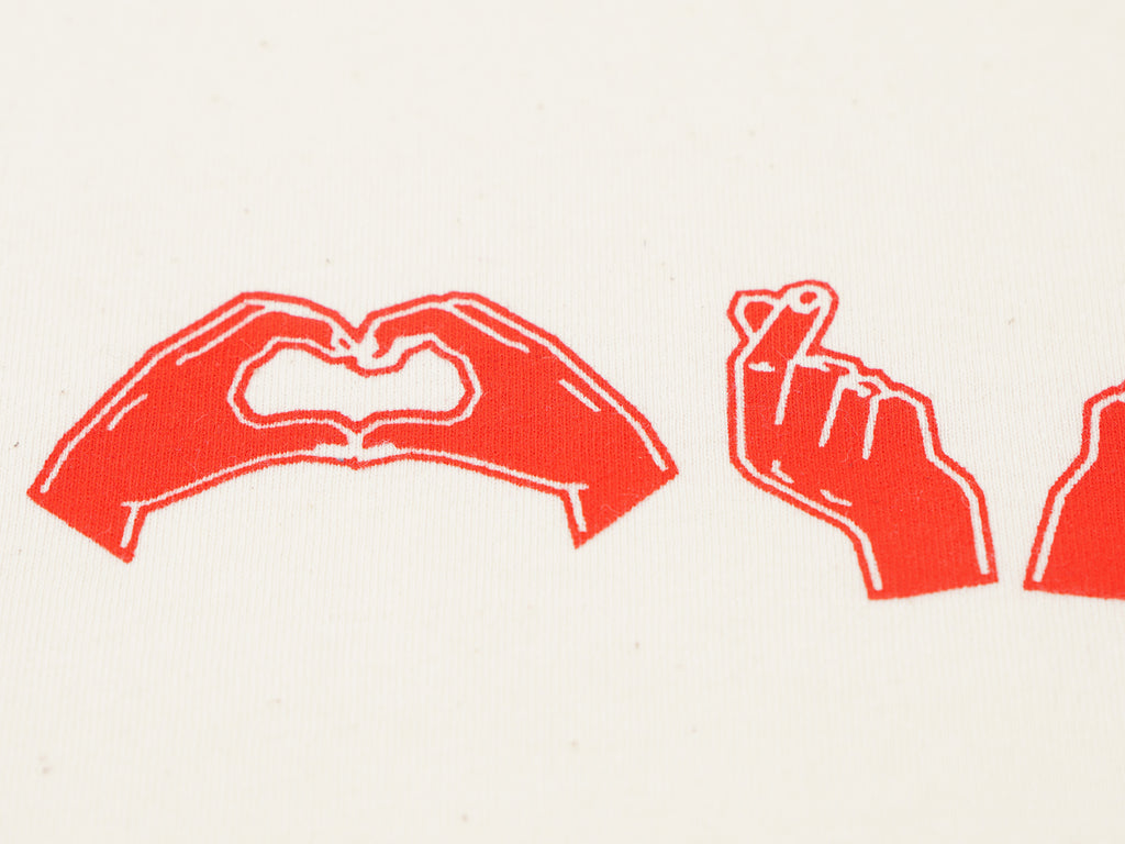 Nahaufnahme des roten Herzgesten-Drucks auf T-Shirt Stoff – Siebdruckdetail mit Herzzeichen-Illustrationen
