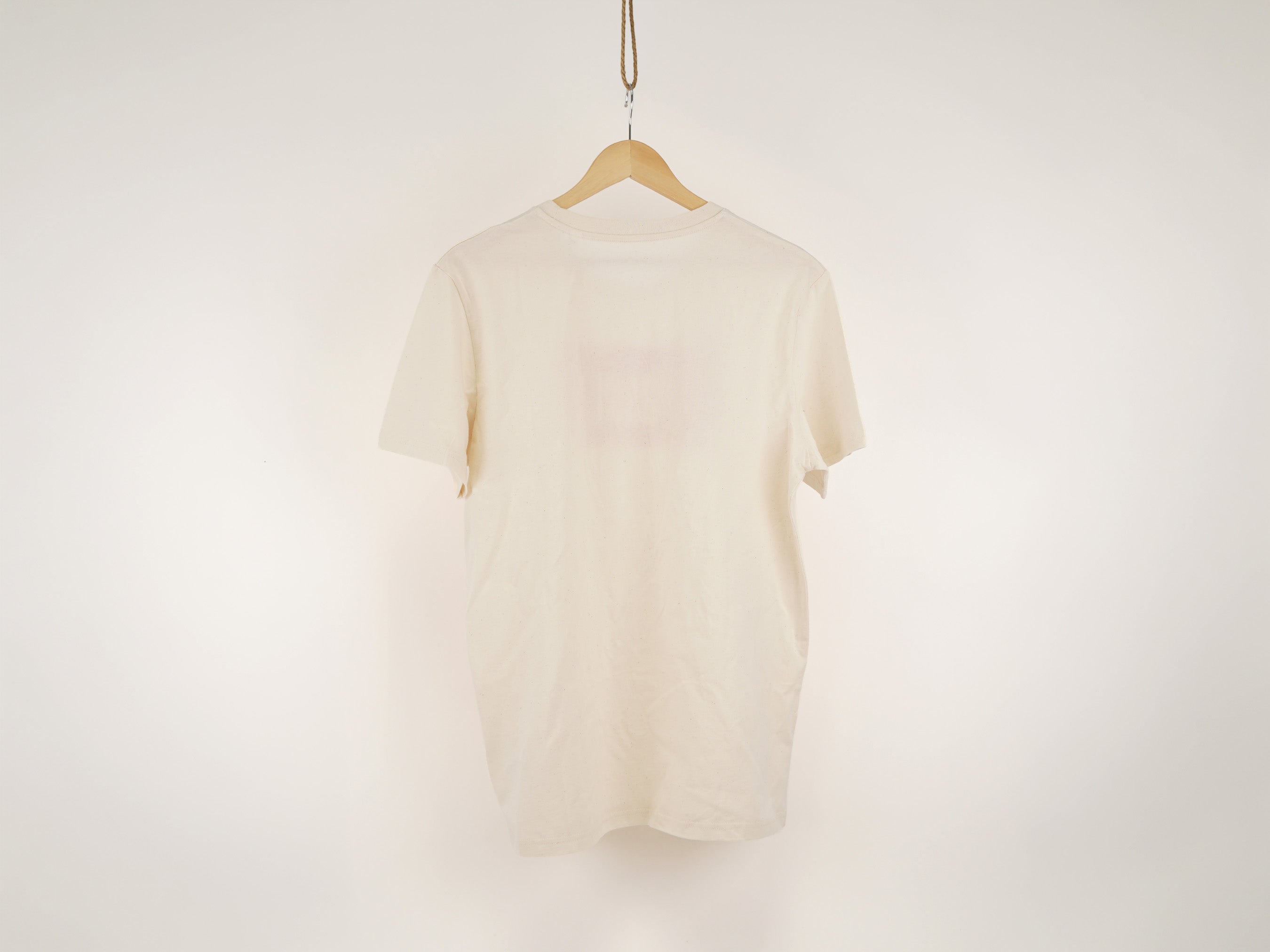 Rückansicht des cremeweißen Passt-T-Shirts, hängend auf Kleiderbügel – unbedruckte Rückseite