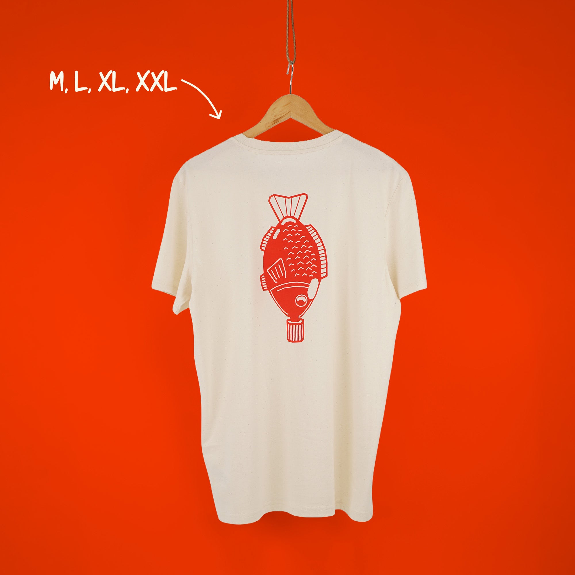 Cremeweißes T-Shirt mit korallrotem Fisch-Aufdruck auf dem Rücken, hängend auf orangem Hintergrund – erhältlich in M, L, XL, XXL